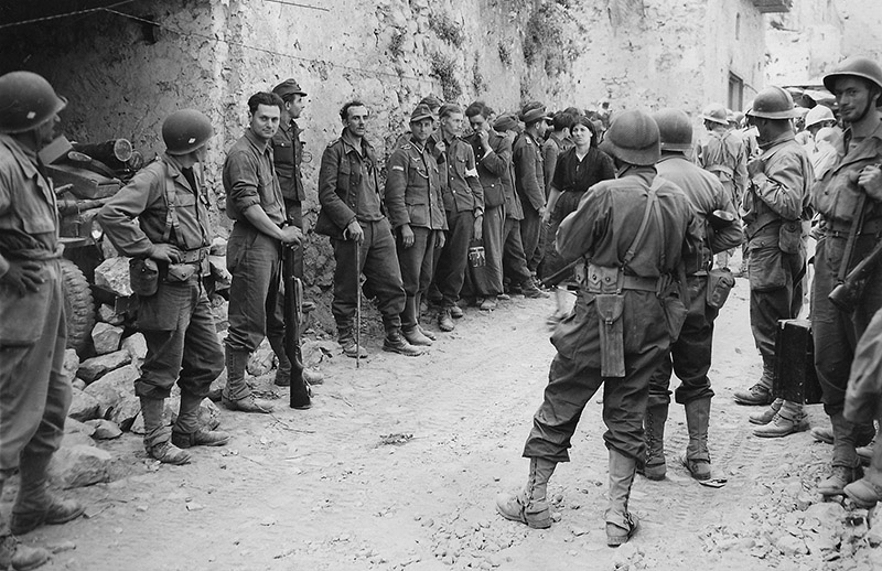 Солдаты 5-й армии сил «Свободной Франции» с немецкими пленными на улице итальянского городка